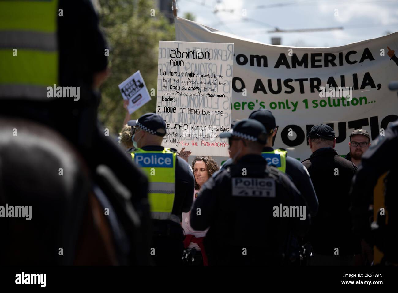 8.. Oktober 2022, Melbourne, Australien. Ein Abtreibungsbefürworter hält ein Schild vor einer Polizeilinie bei einer Gegenkundgebung als Reaktion auf den alljährlich stattfindenden Marsch der Abgeordneten Bernie Finn für die Babys. Quelle: Jay Kogler/Alamy Live News Stockfoto
