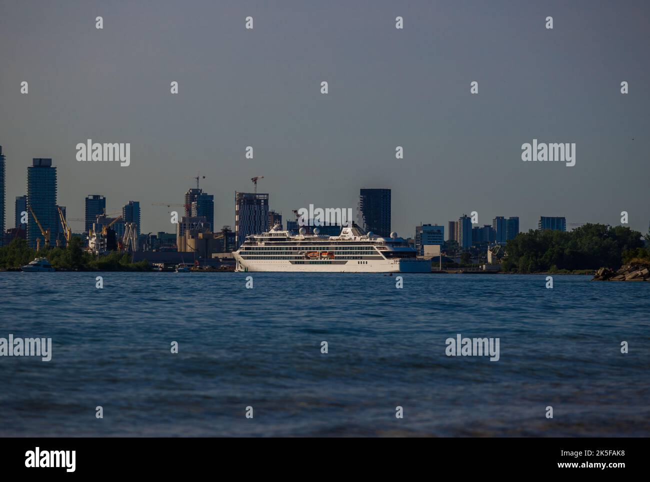 Luxuskreuzfahrtschiff legt bei Sonnenuntergang im Hafen an. Passagierschiff Seeverkehr Stockfoto