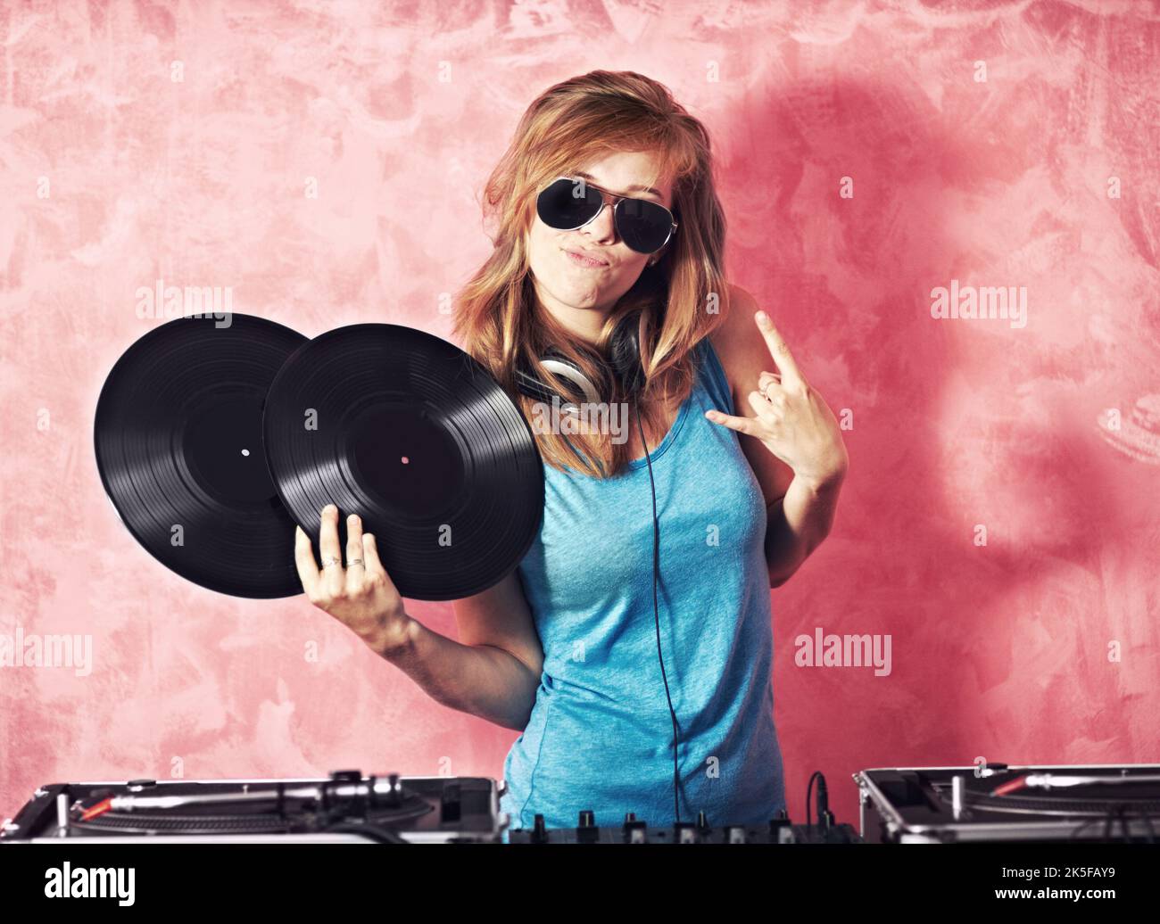 Shell halten Sie unterhalten. Eine junge DJ-Frau, die gestikuliert und Platten hält. Stockfoto