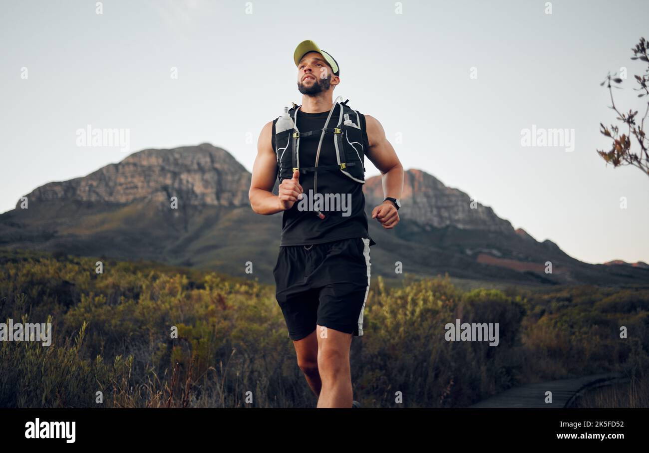 Fitness-Mann läuft allein in der Natur an einem sonnigen Tag im Freien. Muskulöser männlicher Läufer mit Sportbekleidung Laufen Sie mit Geschwindigkeit, Ausdauer und Kardio Stockfoto
