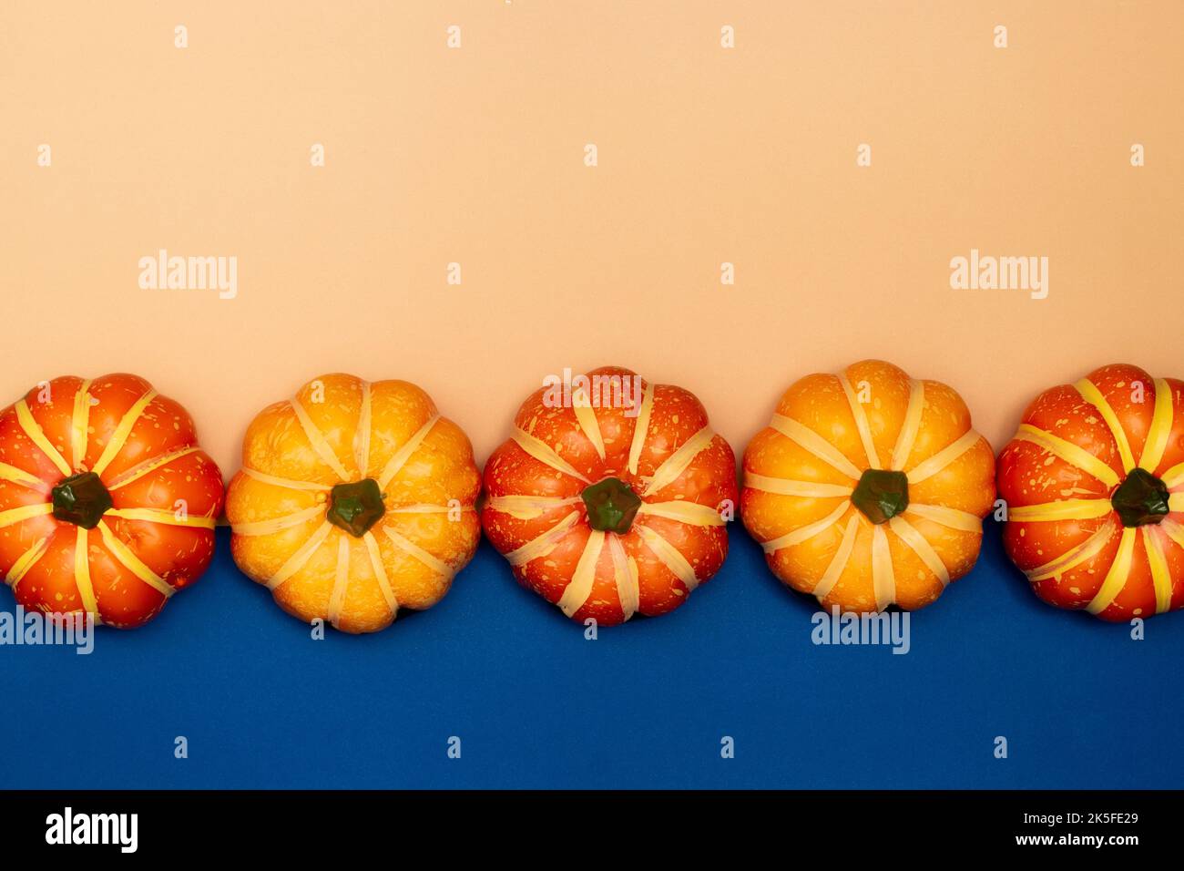 Halloween Dekorationen Konzept, Scary Lächeln Kürbisse sind auf blauen und cremefarbenen Hintergrund angeordnet. Stockfoto