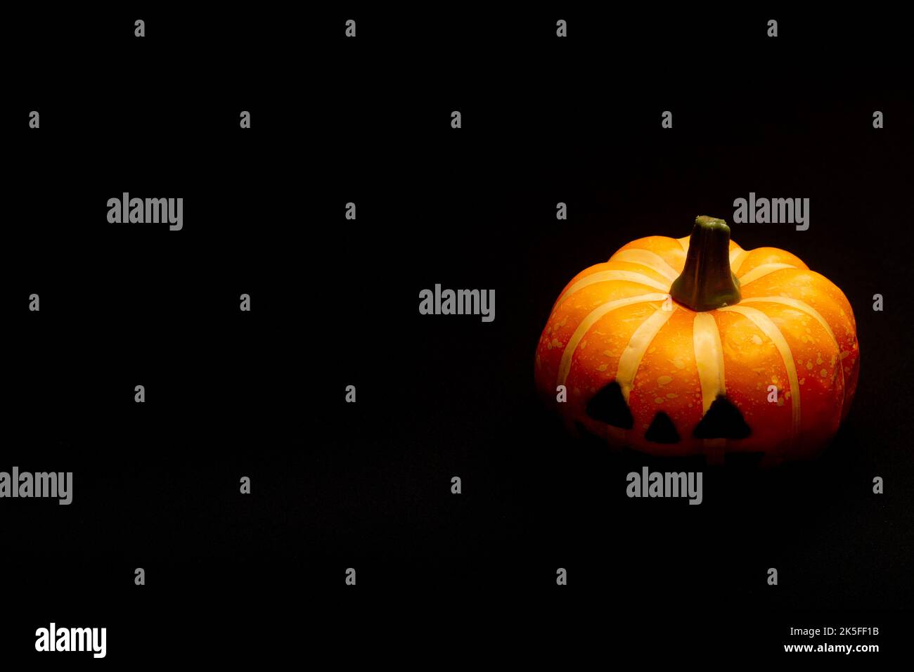 Halloween Dekorationen Konzept, erschreckend lächelnder Kürbis auf schwarzem Hintergrund. Stockfoto