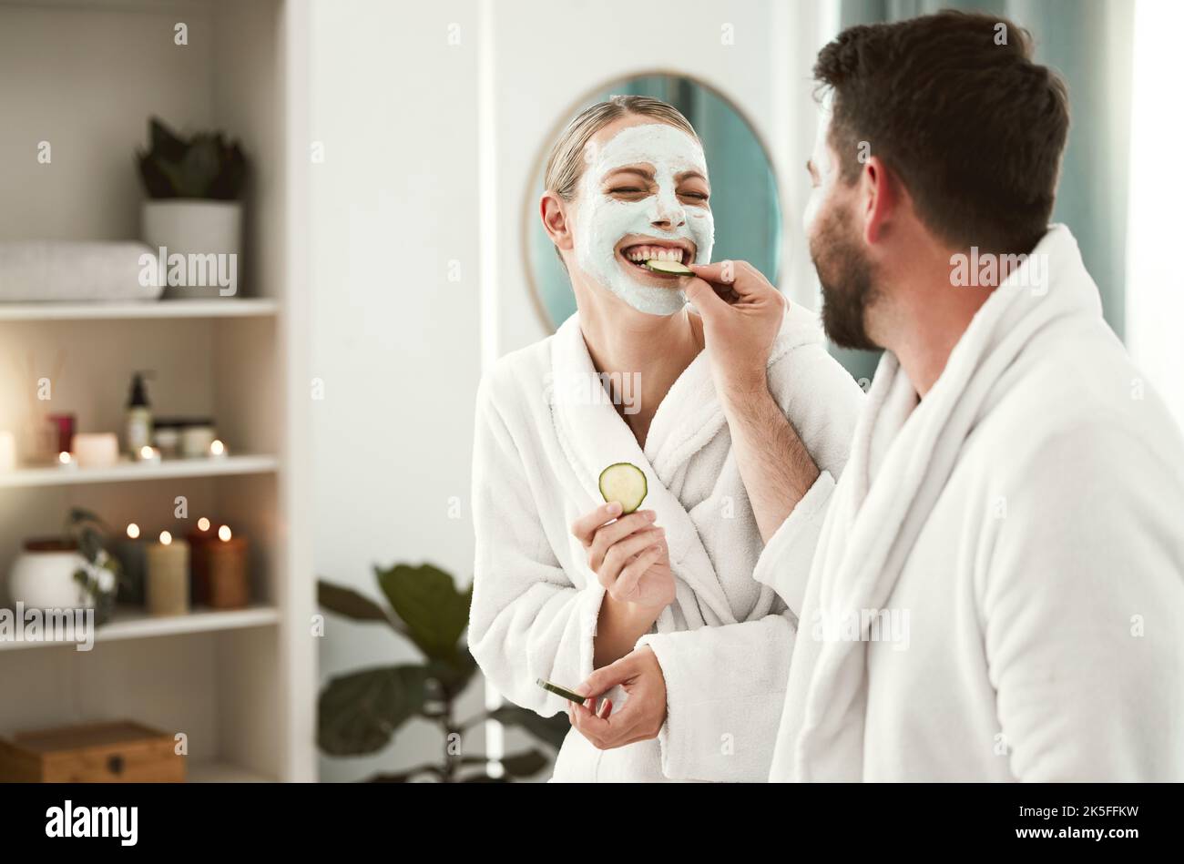 Glückliches Paar verspielt, Gesichtsbehandlung und Entspannung im Spa für Wellness, Hautpflege, Liebe zusammen und essen Gurke. Gesunde Spaß Beziehung, Luxus Körperpflege Stockfoto