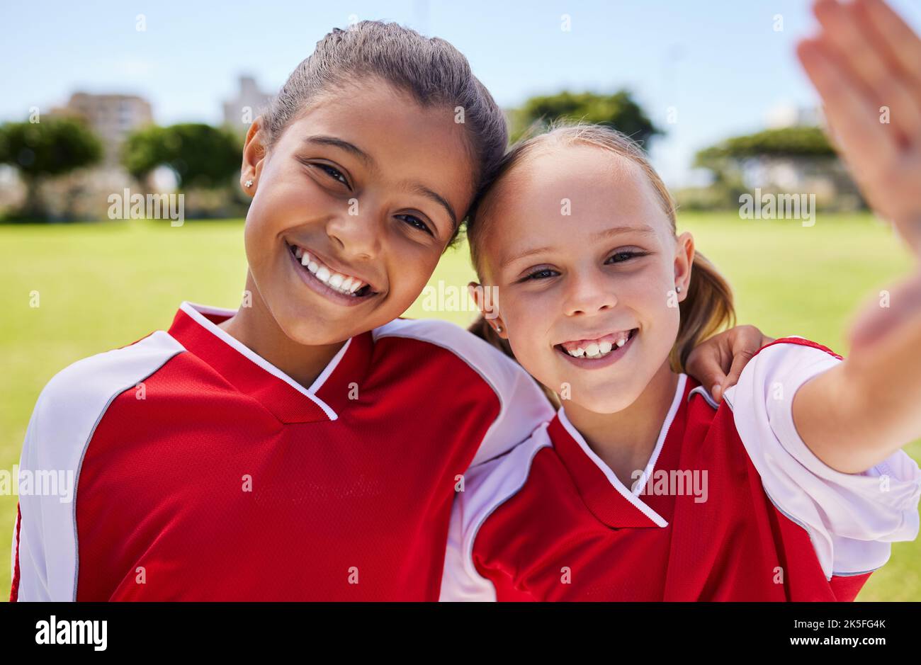 Selfie, Fußball und Sport mit einer Mädchenmannschaft, die vor einem Spiel mit einem Lächeln ein Foto auf einem Fußballfeld macht. Kinder, Sport und Bewegung mit Stockfoto