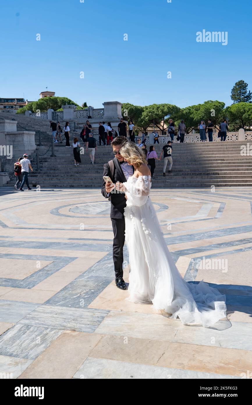 Ein Paar in Hochzeitskleidung im Victor Emmanuel II Monument, (Altare della Patria oder Hochzeitskuchen), Rom, Italien Stockfoto