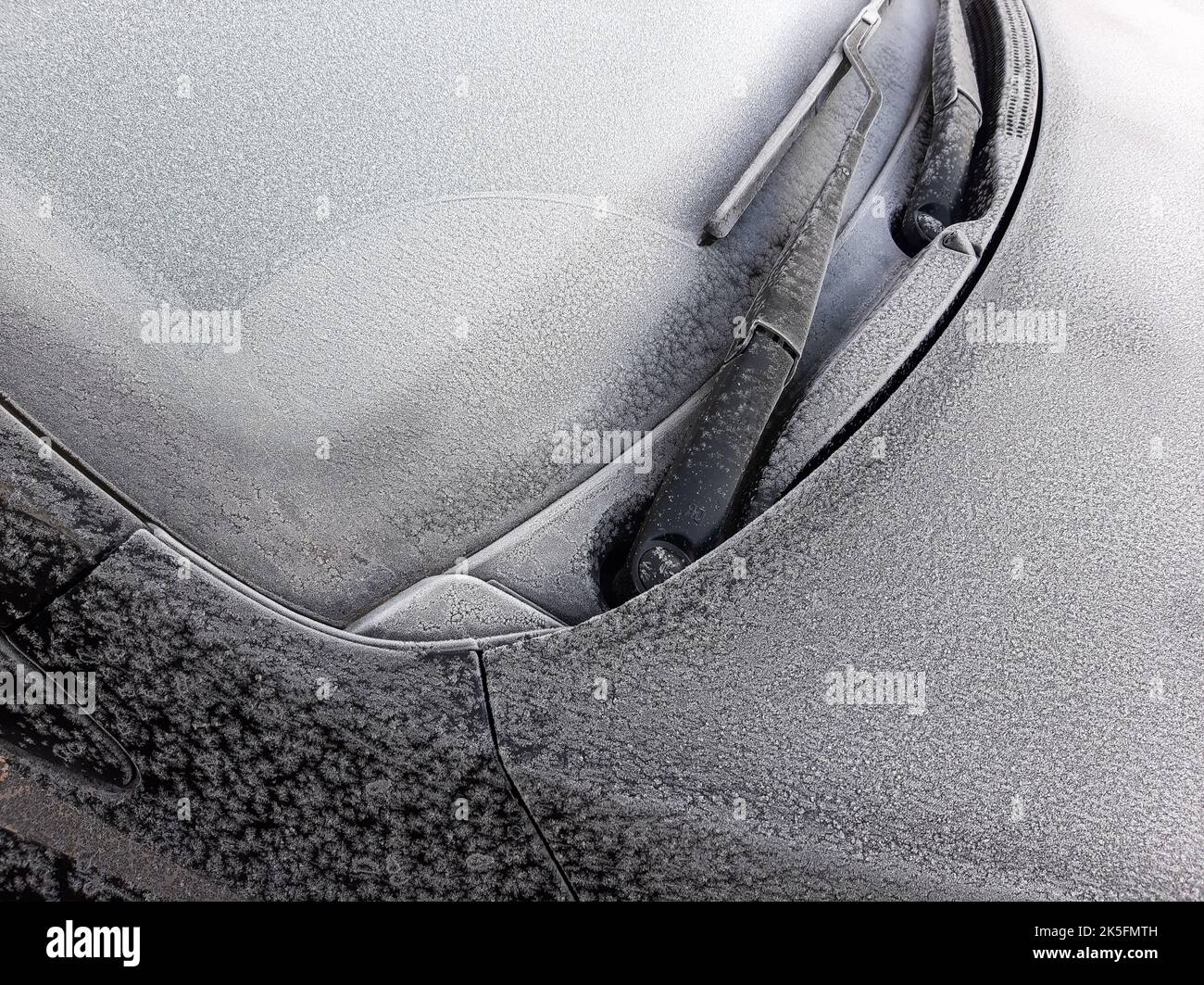 Schneebedecktes Autofenster mit Scheibenwischern, Makro, Nahaufnahme Stockfoto