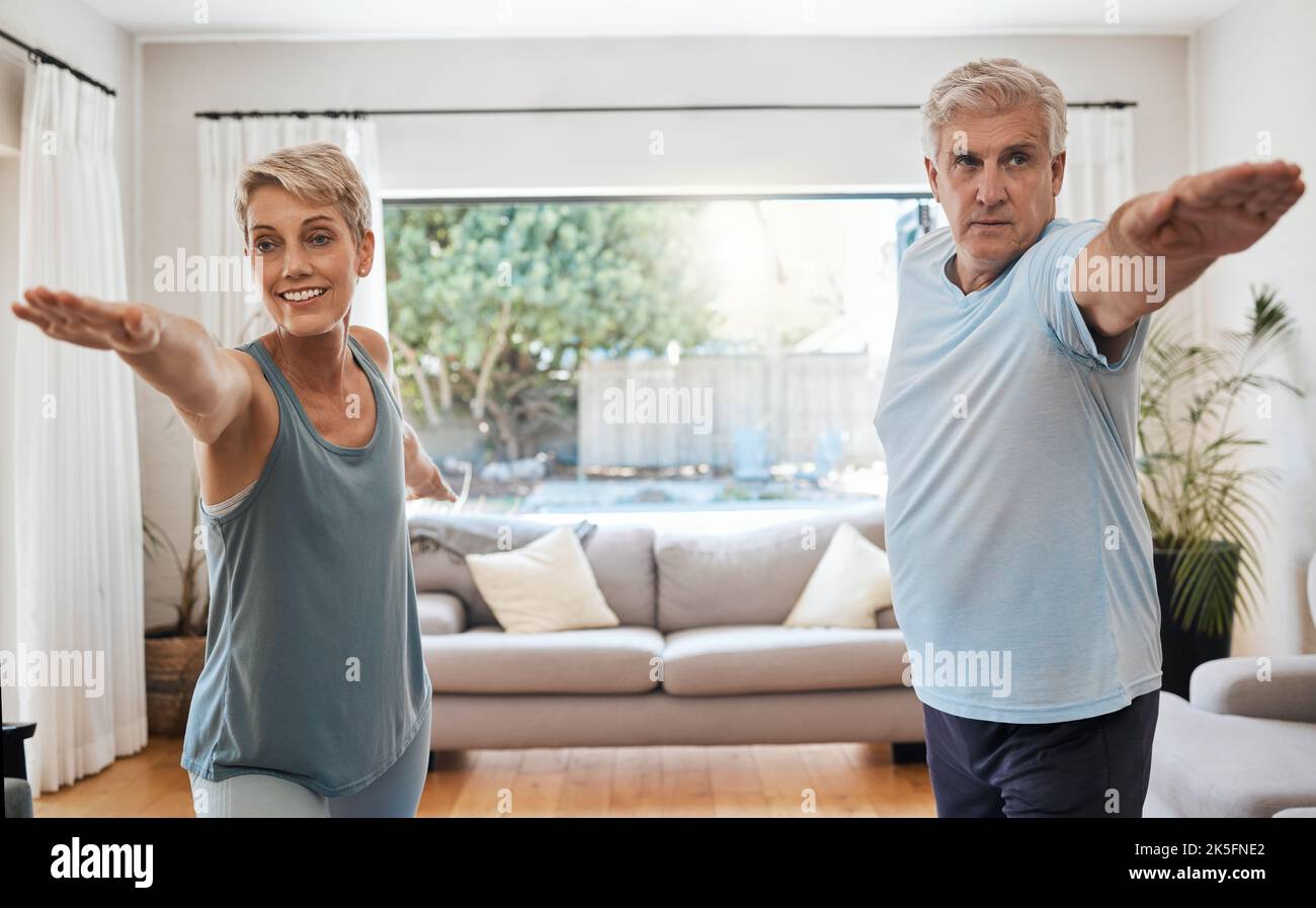Yoga, Training und ein Paar, das zu Hause Sport macht, um aktiv zu bleiben. Alte Frau und Mann machen im Wohnzimmer Fitnesstraining. Gesund Stockfoto