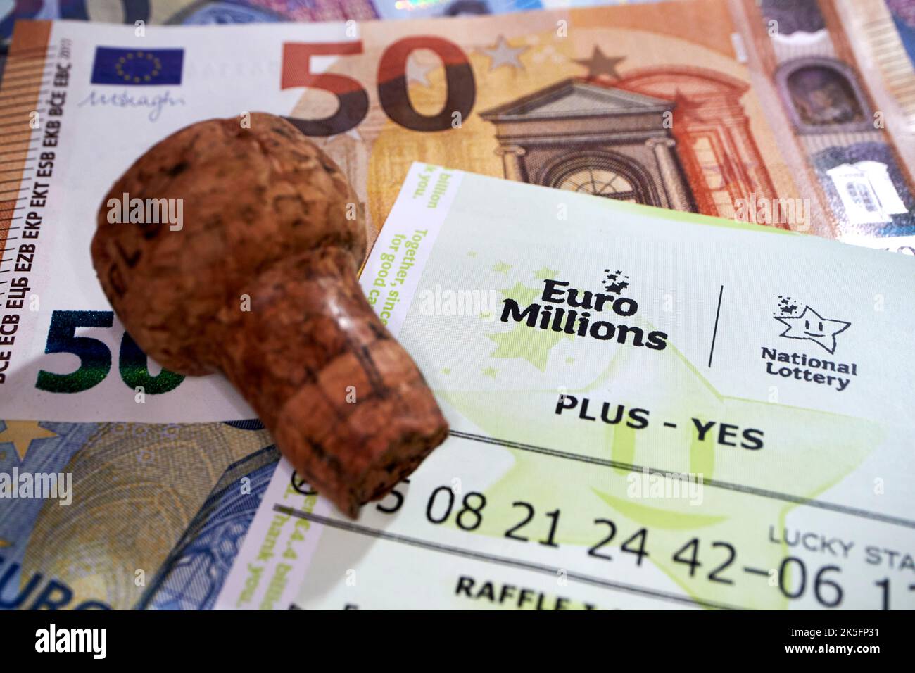 Irische nationale Lotterie euromillions Lotterie-Ticket mit Euro-Bargeld und Champagner Kork bedeutet Gewinnschein Stockfoto