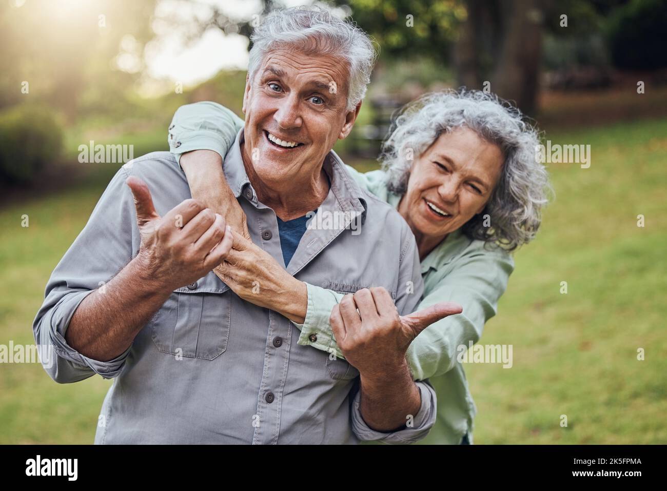 Park, Wellness und Senior Paar mit Daumen nach oben für gesunde Motivation oder Unterstützung im Ruhestand mit grünen Park Linse Flare. Ältere Menschen mit Liebe Stockfoto