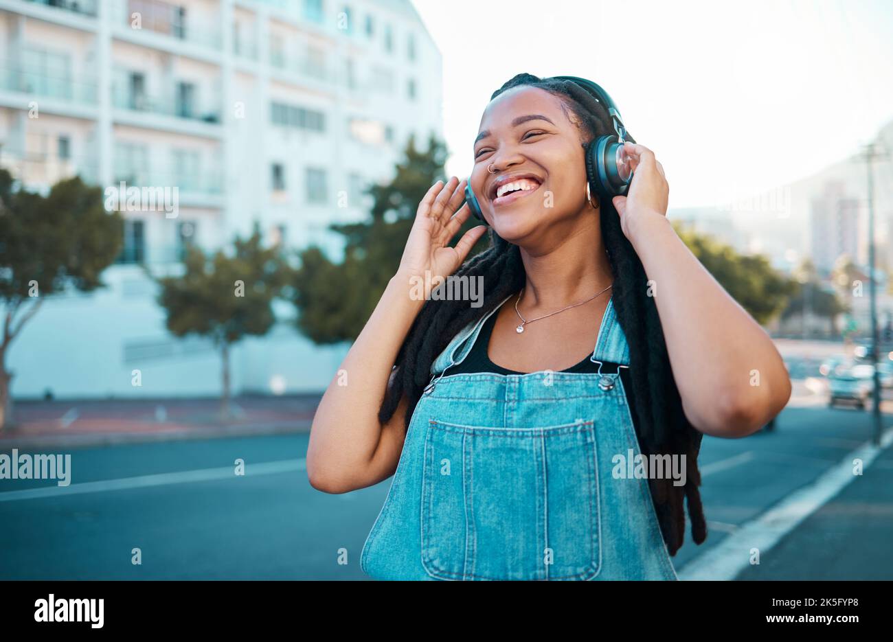 Musik Kopfhörer City Streaming, glückliche und schwarze Frau lächeln draußen aus Atlanta. Das Glück einer Person, die sich entspannt und fröhlich fühlt Stockfoto