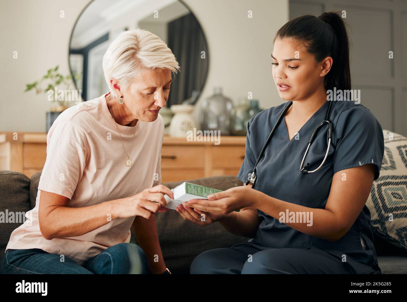 Heim, Gesundheitswesen und Arzt helfen älteren Patienten in betreuten Wohnheim Pflegeeinrichtung, erklären Medizin auf einem Sofa. Unterstützung, Pillen und Vorsorgeuntersuchung Stockfoto