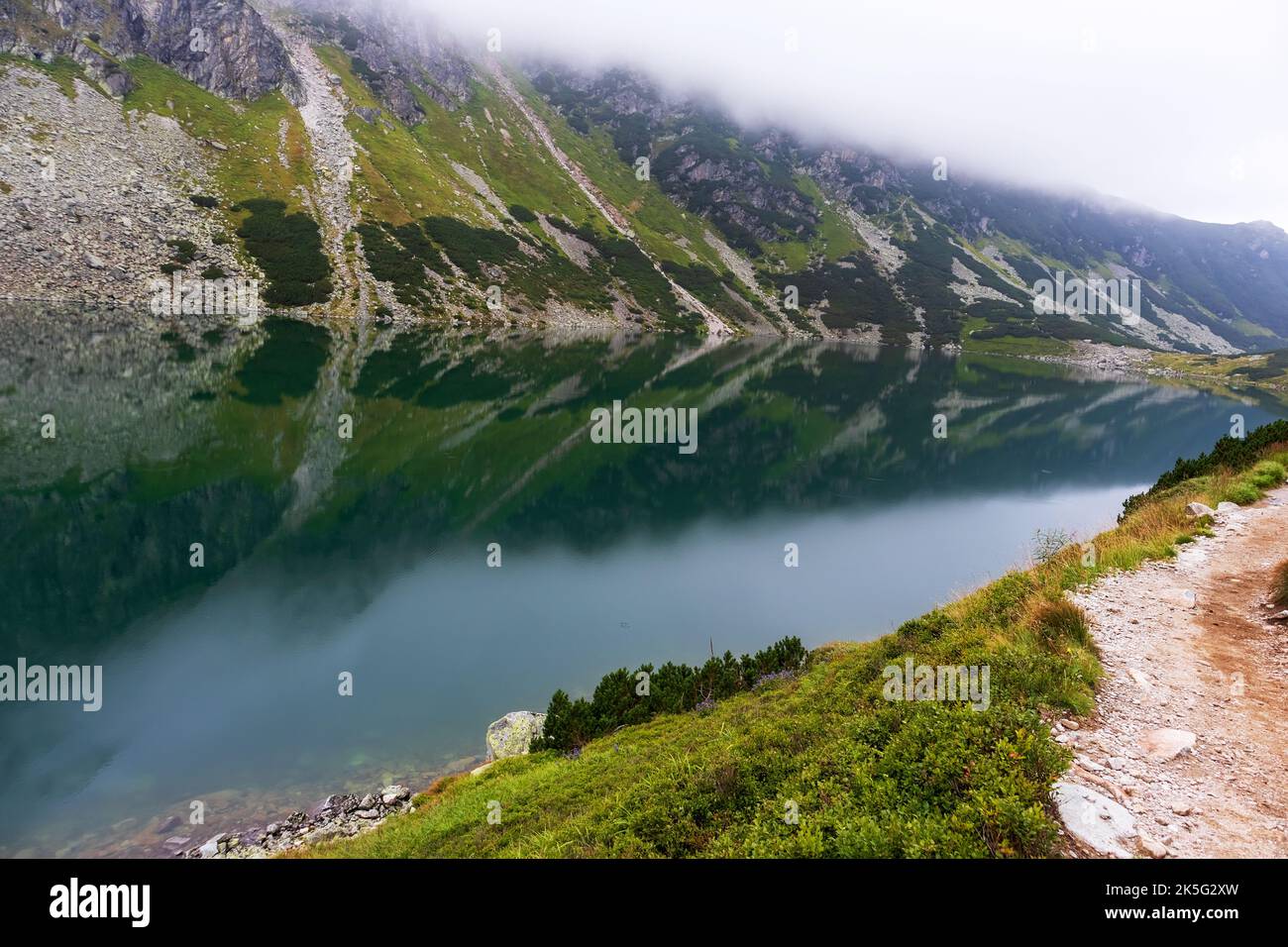 Eine sehr beeindruckende Aussicht auf die polnische Tatra mit vielen Felsen mit einem unglaublich schönen türkisfarbenen See mitten in den Bergen mit dem RE Stockfoto