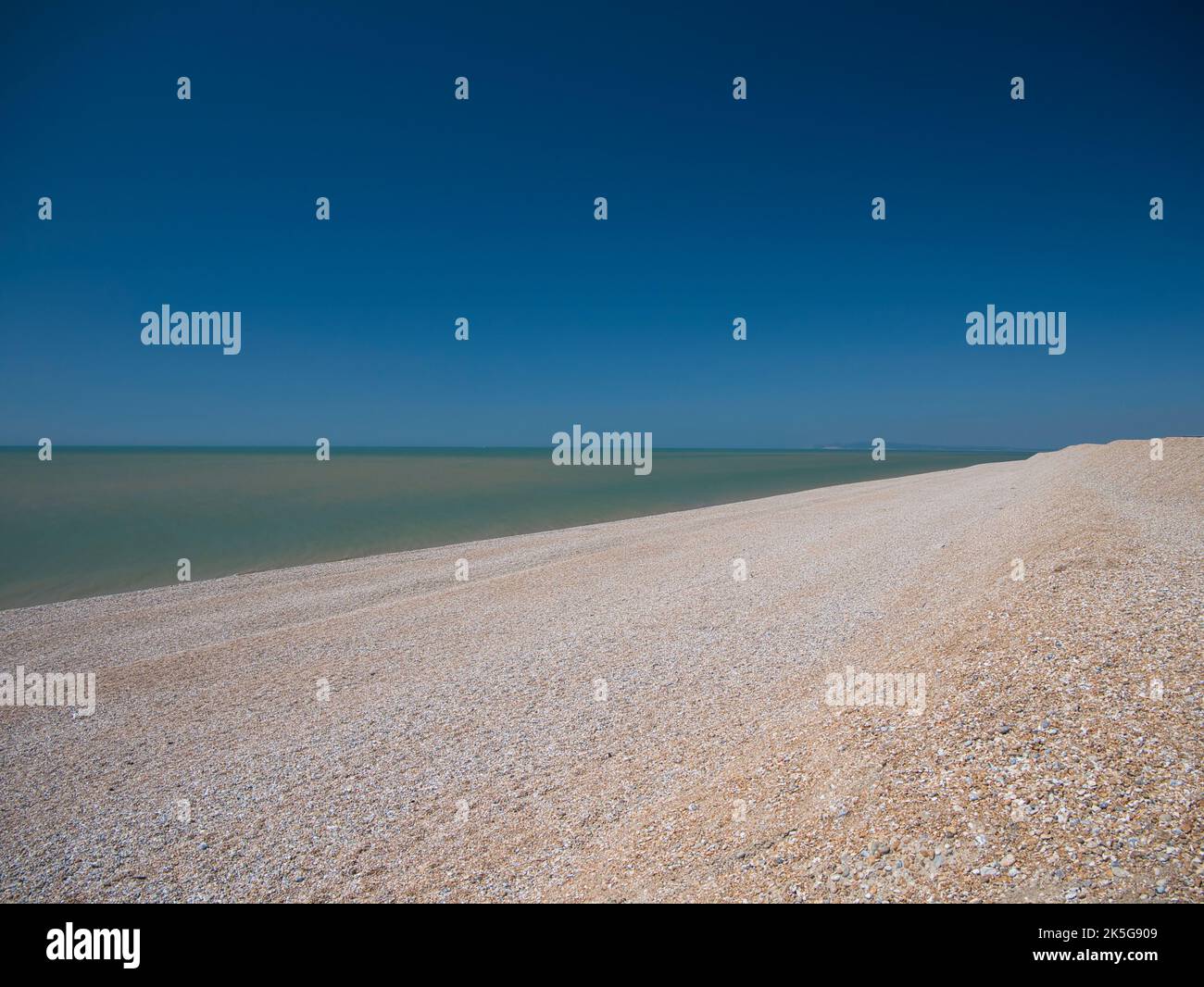 Der offene, menschenleere Kiesstrand in Dungeness, Kent, Großbritannien. Aufgenommen an einem sonnigen Tag im Sommer. Stockfoto