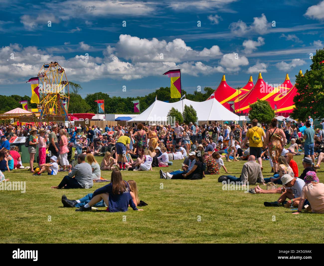 Ein großes Publikum bei einem Sommer-Musikfestival im Freien in England, Großbritannien. Aufgenommen an einem sonnigen Tag mit blauem Himmel. Stockfoto