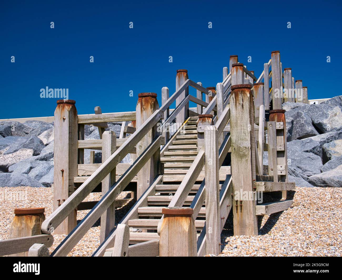 Verwitterte Holztreppen ermöglichen den Zugang zum Strand von Camber Sands in East Sussex an der Südküste Großbritanniens. Aufgenommen an einem sonnigen Tag im Sommer. Stockfoto