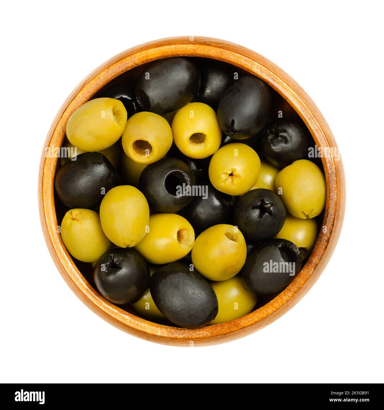 Grüne und schwarze Oliven, Hojiblanca, in einer Holzschale entsteint. Europäische Oliven, Olea europaea. Beliebte Tafeloliven mit einem geringeren Ölgehalt. Stockfoto