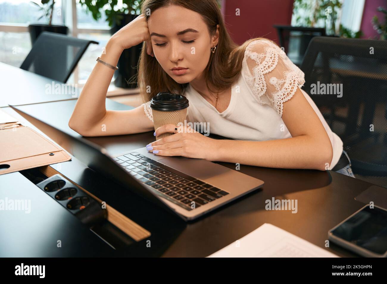 Müde Mitarbeiter im Unternehmen, die am Laptop abdösen Stockfoto