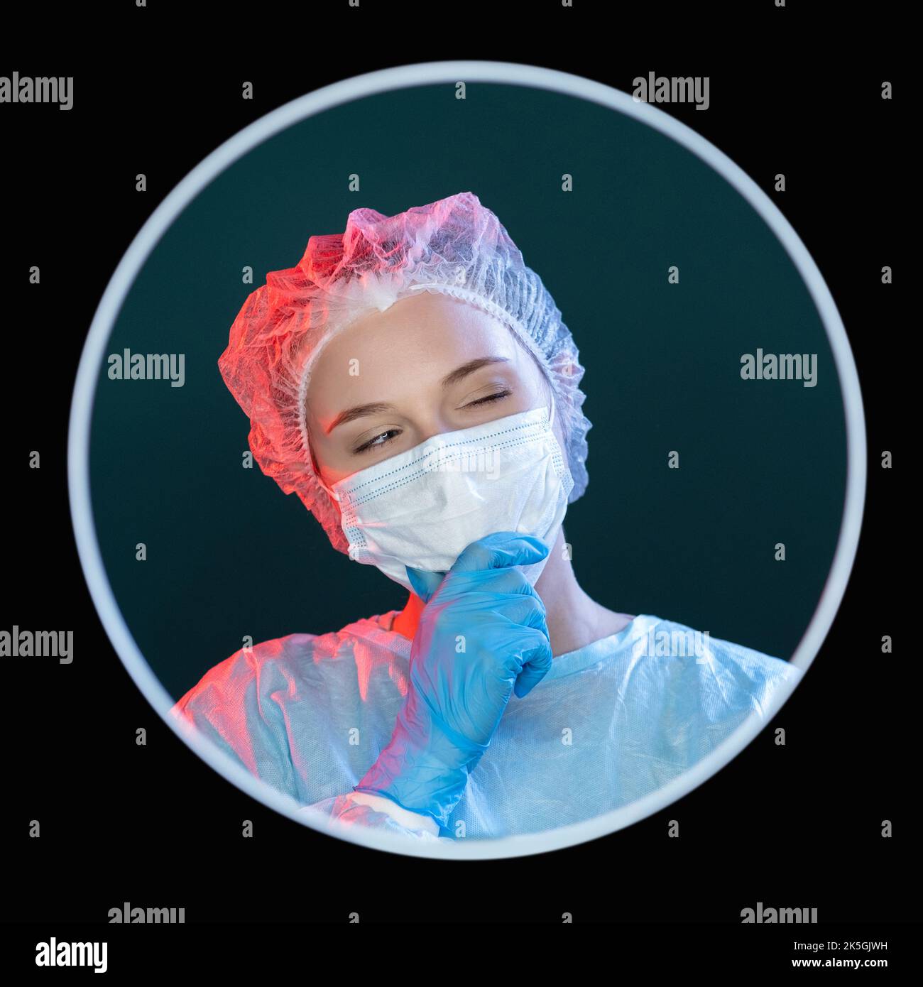 Skeptisches Arztportrait. Laborforschung. Gesundheitsfachkraft. Kopfschuss einer nachdenklichen neugierigen Chirurgen in blauer ppe-Schutzmaske glo Stockfoto