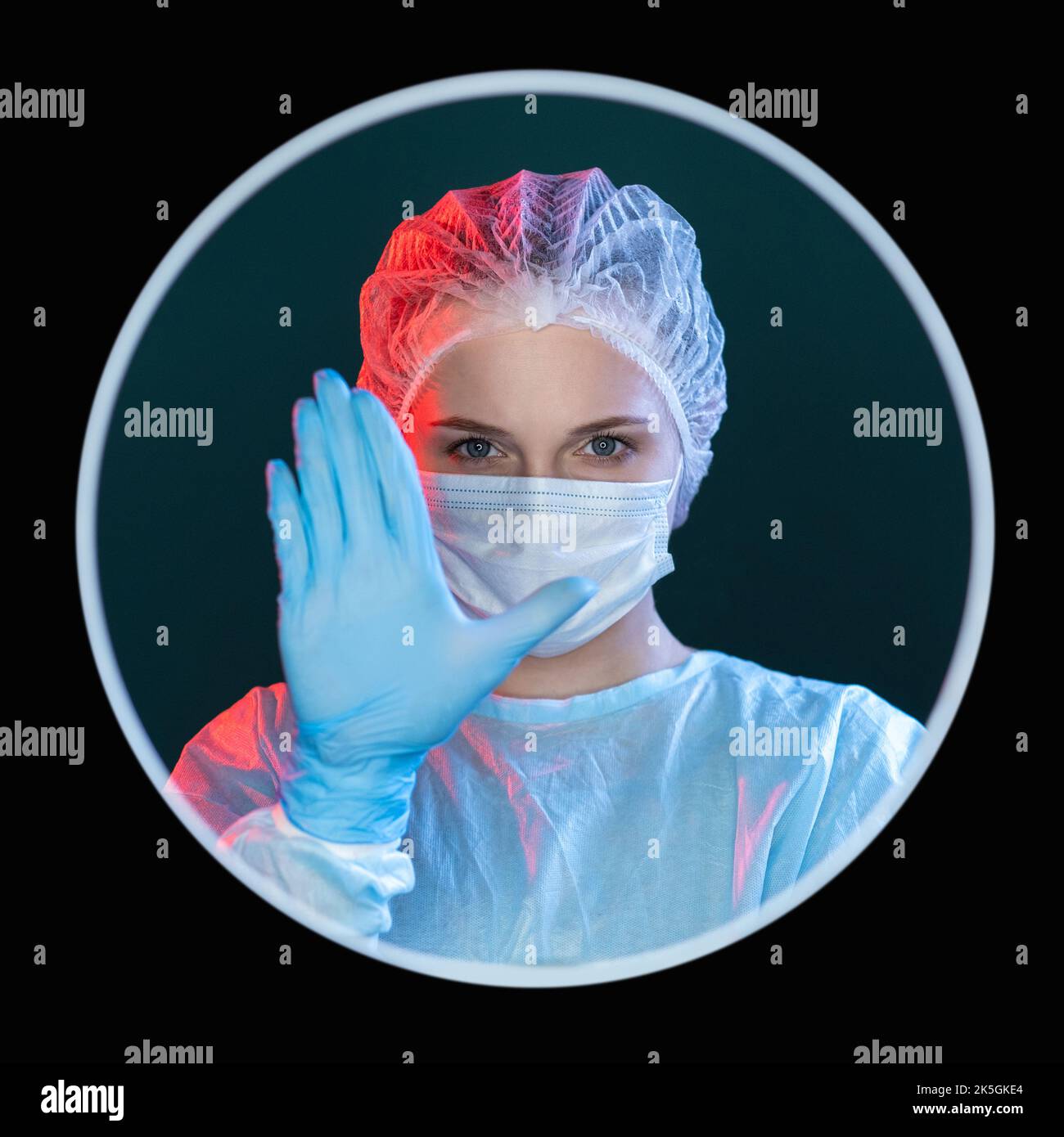 Warnung des Arztes. Quarantänebeschränkung. Gefahr für Gesundheitsrisiken. Kopfbild einer Krankenschwester in blauen ppe-Gesichtsmasken-Handschuhen mit Stop-Hand-Geste i Stockfoto