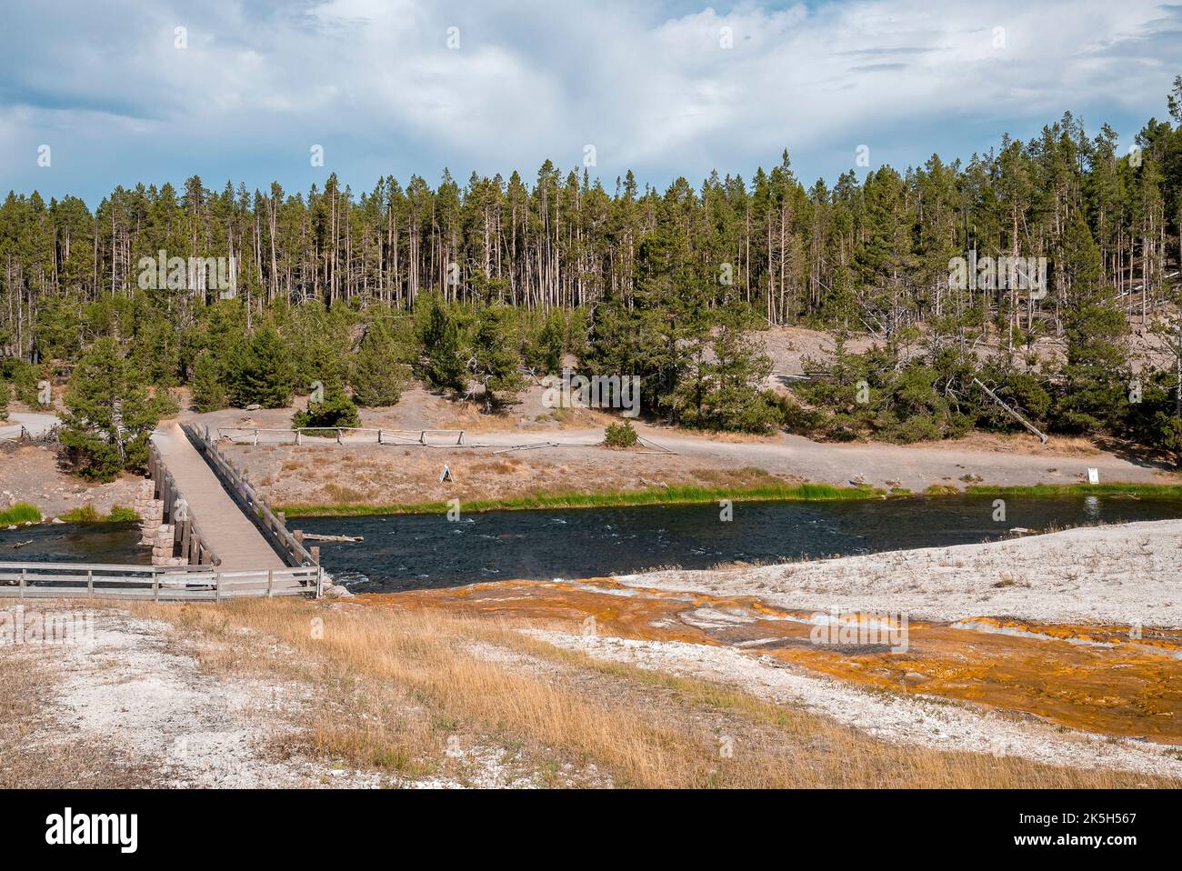 Holzbrücke über den Fluss im Wald im Yellowstone Park mit Himmel im Hintergrund Stockfoto