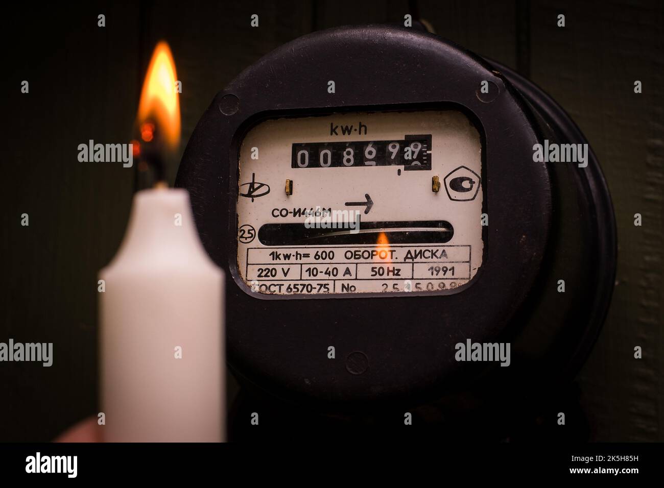 Überprüfung der alten retro elektrischen Meter mit Kerzenlicht. Selektiver Fokus auf Feuer. Stockfoto
