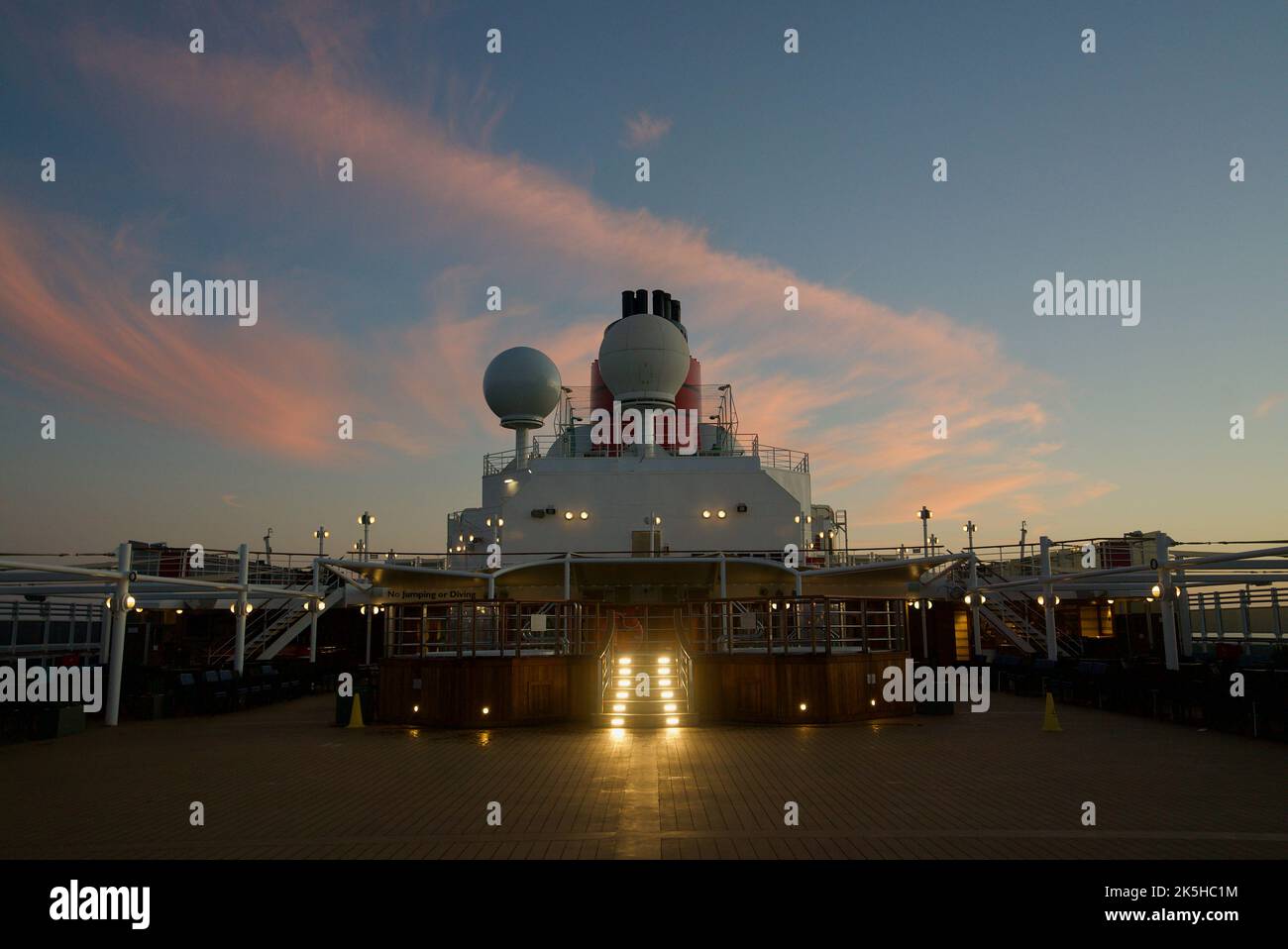 Der Blick auf das obere Deck des Queen Victoria-Kreuzfahrtschiffs, eine Cunard-Kreuzfahrt. Queen Victoria Oberdeck, Deck 9. Sonnenuntergang. Stockfoto