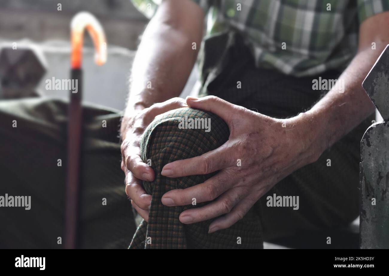 Kniegelenkschmerzen beim älteren Mann aus dem asiatischen Myanmar. Konzept von Osteoarthritis, rheumatoider Arthritis, Patellartendonitis, präpatellarer Bursitis, kollateraler Lig Stockfoto Kniegelenkschmerzen beim älteren Mann aus dem asiatischen Myanmar. Konzept von Osteoarthritis, rheumatoider Arthritis, Patellartendonitis, präpatellarer Bursitis, kollateraler Lig Stockfoto
