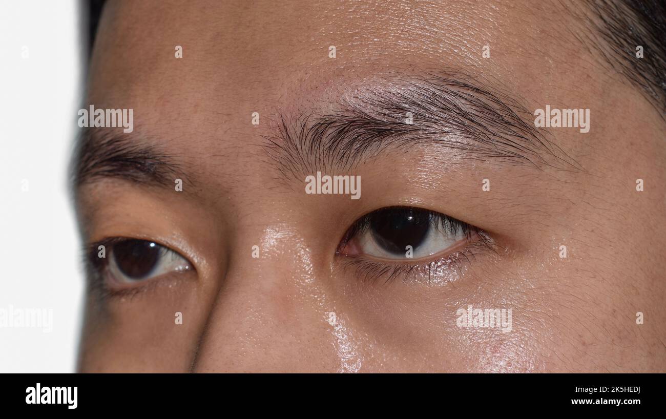 Südostasiatischer, chinesischer junger Mann mit einem einzigen Augenlid oder Monolid. Ein Monolid bedeutet, dass sich unterhalb des Brauenbereichs keine sichtbare Faltenlinie befindet. Stockfoto