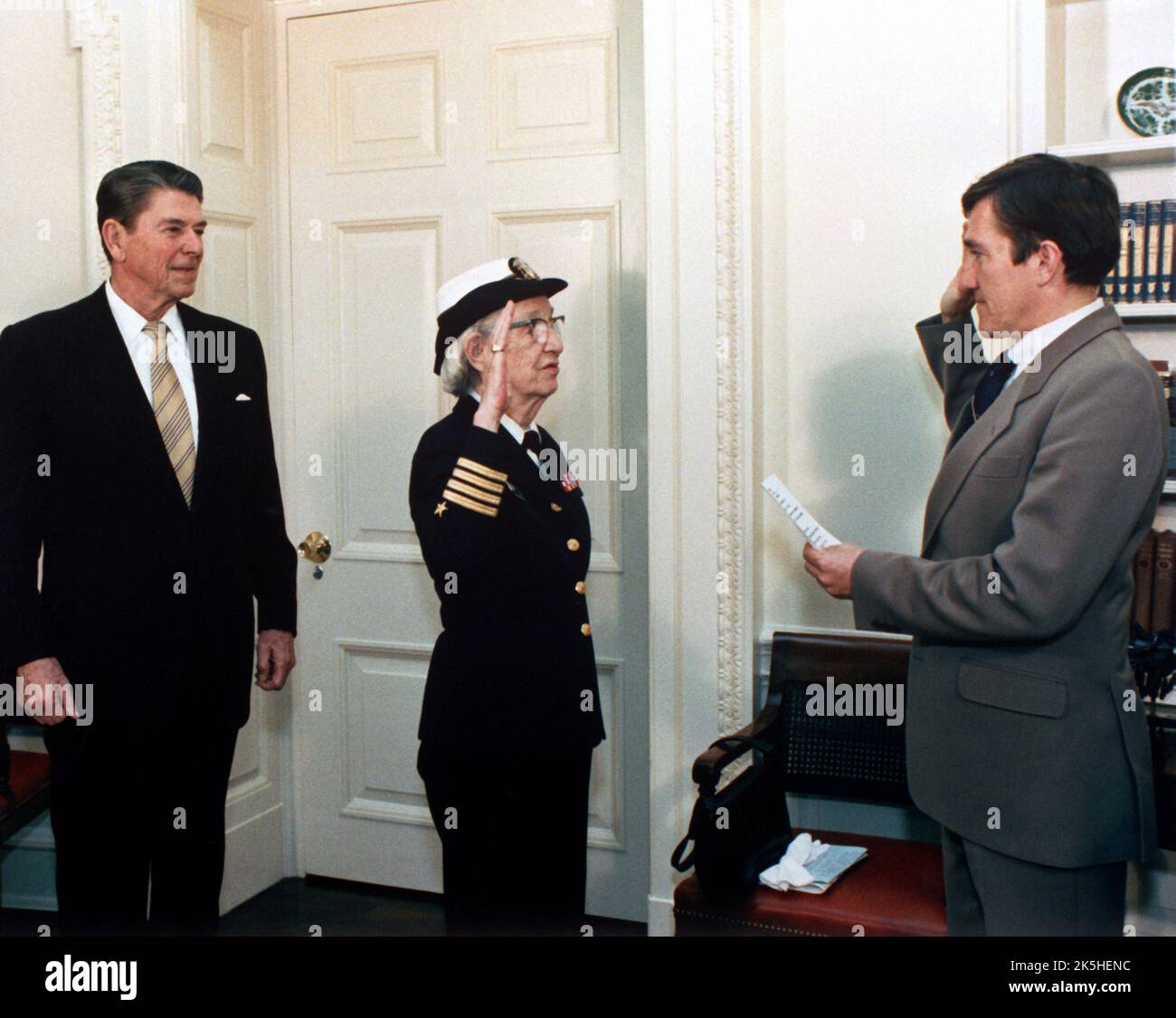 Der Navy-Sekretär John Lehman, rechts, befördert Capt. Grace Hopper in einer Zeremonie im Weißen Haus zum commodore. Präsident Ronald Reagan befindet sich auf der linken Seite. Hopper wird 1983 zum commodore befördert. Grace Brewster Murray Hopper (1906 – 1992) amerikanischer Informatiker, Mathematiker und Rückadmiral der United States Navy. Stockfoto