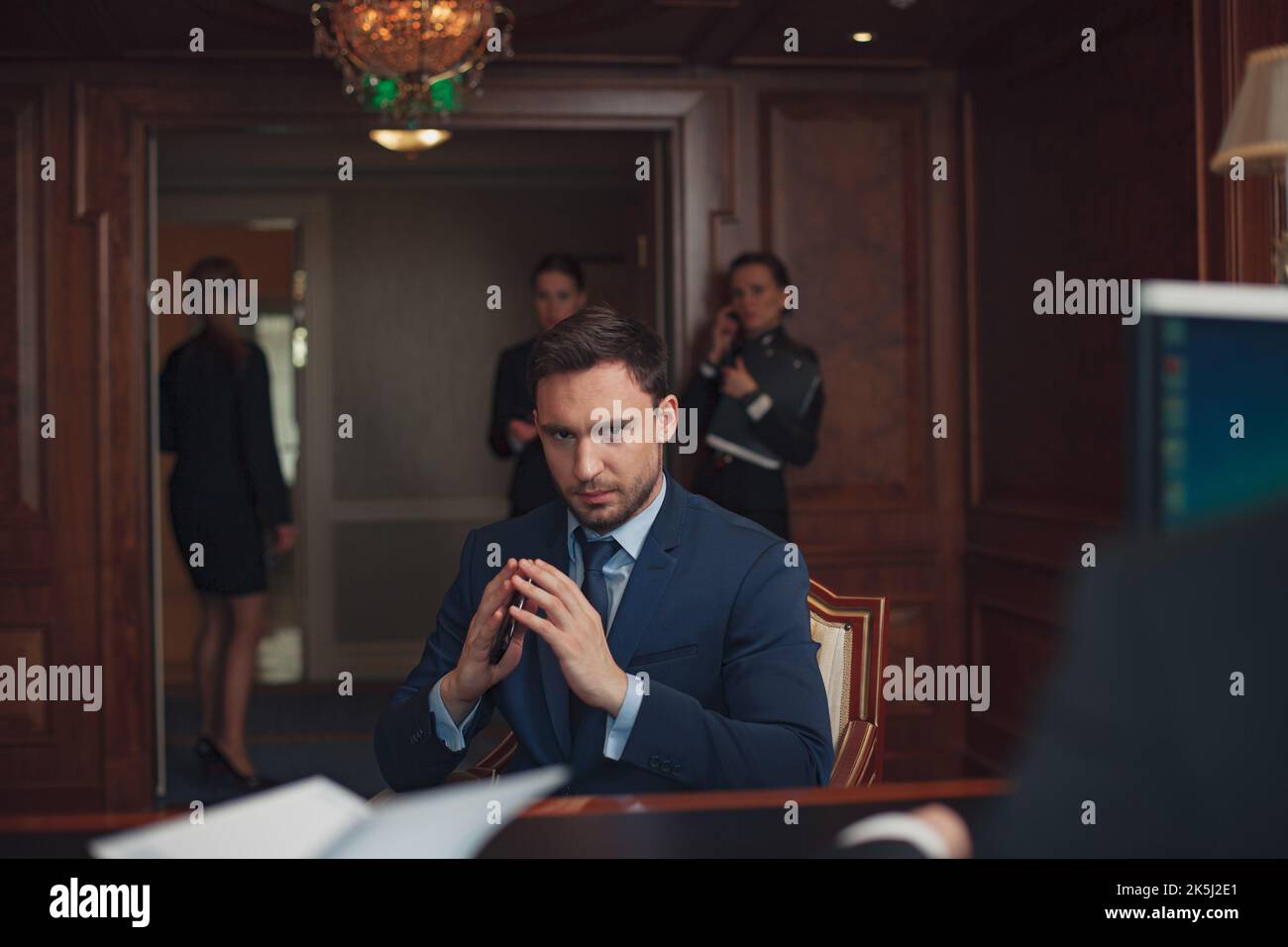 Ein gutaussehender Geschäftsmann in Anzug im Hotel checke an der Rezeption oder an der Rezeption ein Stockfoto