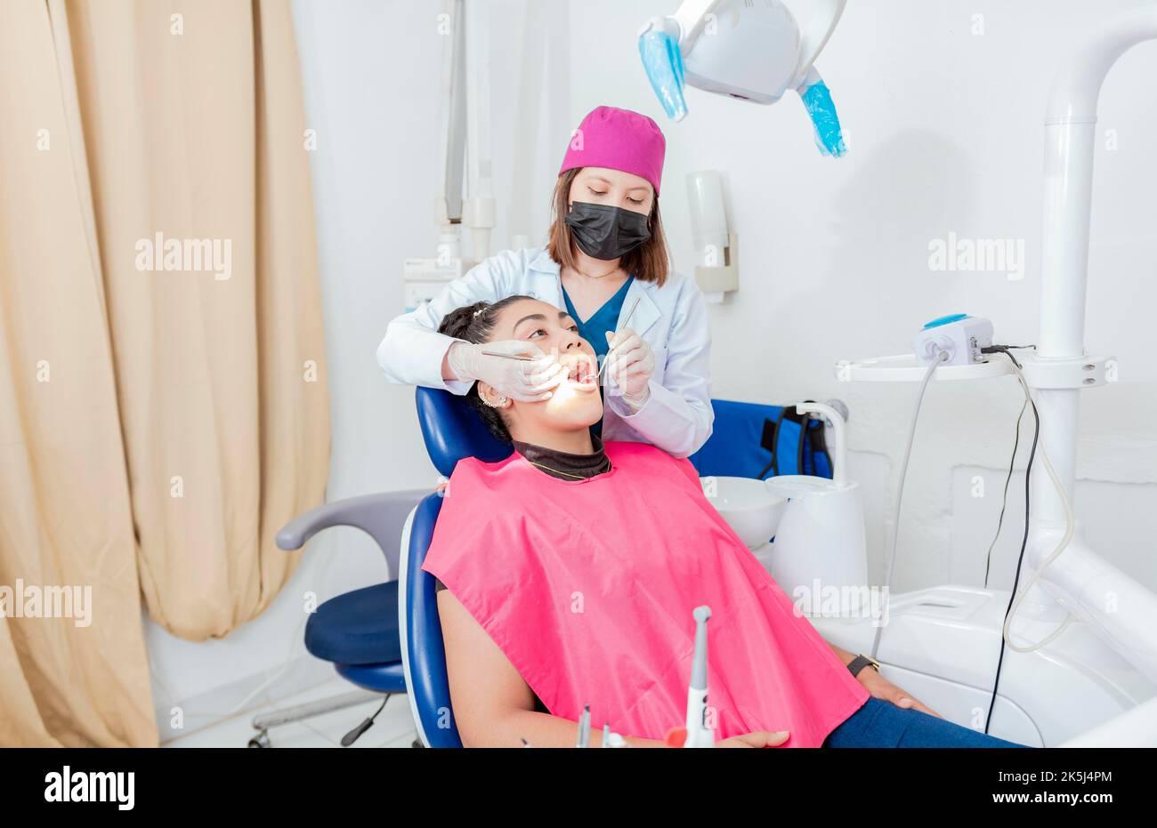 Zahnärztin mit Sonde und Zahnspiegel, die den Mund bis zum Patienten untersucht. Gesundheit und Zahnpflege Konzept, Zahnarzt Arzt Untersuchung Mund zu Stockfoto