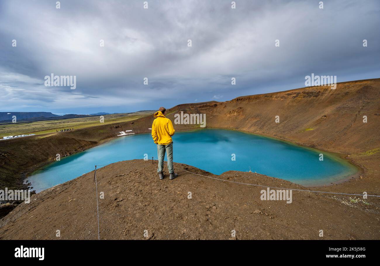 Tourist am Vulkankrater mit blauem See, vulkanischem See, Kratersee Viti am zentralen Vulkan Krafla, Myvatn, Nordisland, Island Stockfoto