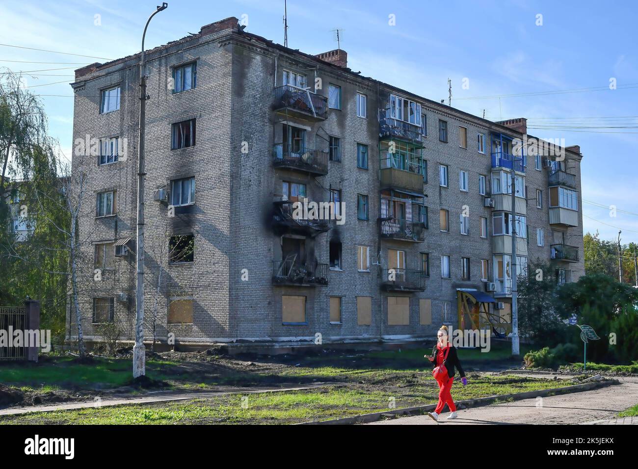 Eine Frau kommt an einem Wohngebäude vorbei, das durch einen russischen Beschuss in Sloviansk schwer beschädigt wurde. In den letzten Wochen hat die ukrainische Armee in einer erfolgreichen Gegenoffensive große Teile des Territoriums zurückerobert, die russische Truppen gezwungen hat, lange gehaltene Positionen aufzugeben. In dem, was Kiew als Moskaus Reaktion auf seine Niederlagen beschreibt, hat Präsident Wladimir Putin vier teilweise besetzte Regionen der Ukraine eingegliedert. Die Annexionen, die weithin als illegal abgetan wurden, haben Befürchtungen über eine mögliche Eskalation im siebenmonatigen Krieg geweckt. Stockfoto