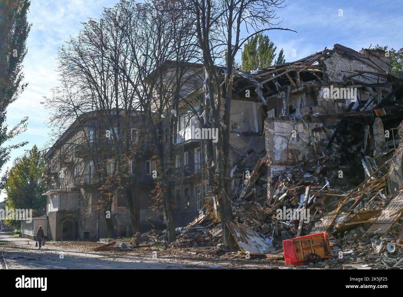 Eine Frau kommt an einem Wohngebäude vorbei, das von einem russischen Beschuss in Slowiansk zerstört wurde. In den letzten Wochen hat die ukrainische Armee in einer erfolgreichen Gegenoffensive große Teile des Territoriums zurückerobert, die russische Truppen gezwungen hat, lange gehaltene Positionen aufzugeben. In dem, was Kiew als Moskaus Reaktion auf seine Niederlagen beschreibt, hat Präsident Wladimir Putin vier teilweise besetzte Regionen der Ukraine eingegliedert. Die Annexionen, die weithin als illegal abgetan wurden, haben Befürchtungen über eine mögliche Eskalation im siebenmonatigen Krieg geweckt. (Foto von Andriy Andriyenko/SOPA Images/Sipa USA) Stockfoto