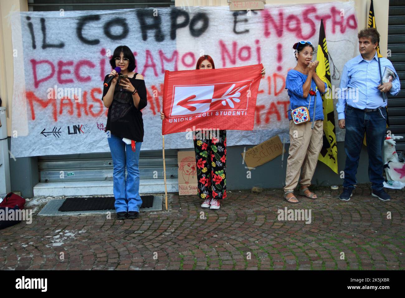 Salerno, Italien - Oktober 08/2022 : Junge Studenten und Freiwillige von Verbänden, nahmen an der Veranstaltung Teil, um ihre Nähe zu iranischen Frauen nach dem Tod von Mahsa Amini auszudrücken. Der Iran kurdischer Abstammung, der am 22. Juni von der moralischen Polizei getötet wurde, ist seit der Nachricht von ihrem Tod auf den Straßen des Iran mit Demonstranten gefüllt, die mehr Freiheit und mehr Rechte fordern. Die Regierung reagierte mit gewaltsamer Unterdrückung der Proteste und einer Internetblockade in der Hauptstadt, während die Städte im Rest des Landes keinen Zugang mehr zu Whatsapp und Instagram haben.eine aktivistische Spea Stockfoto