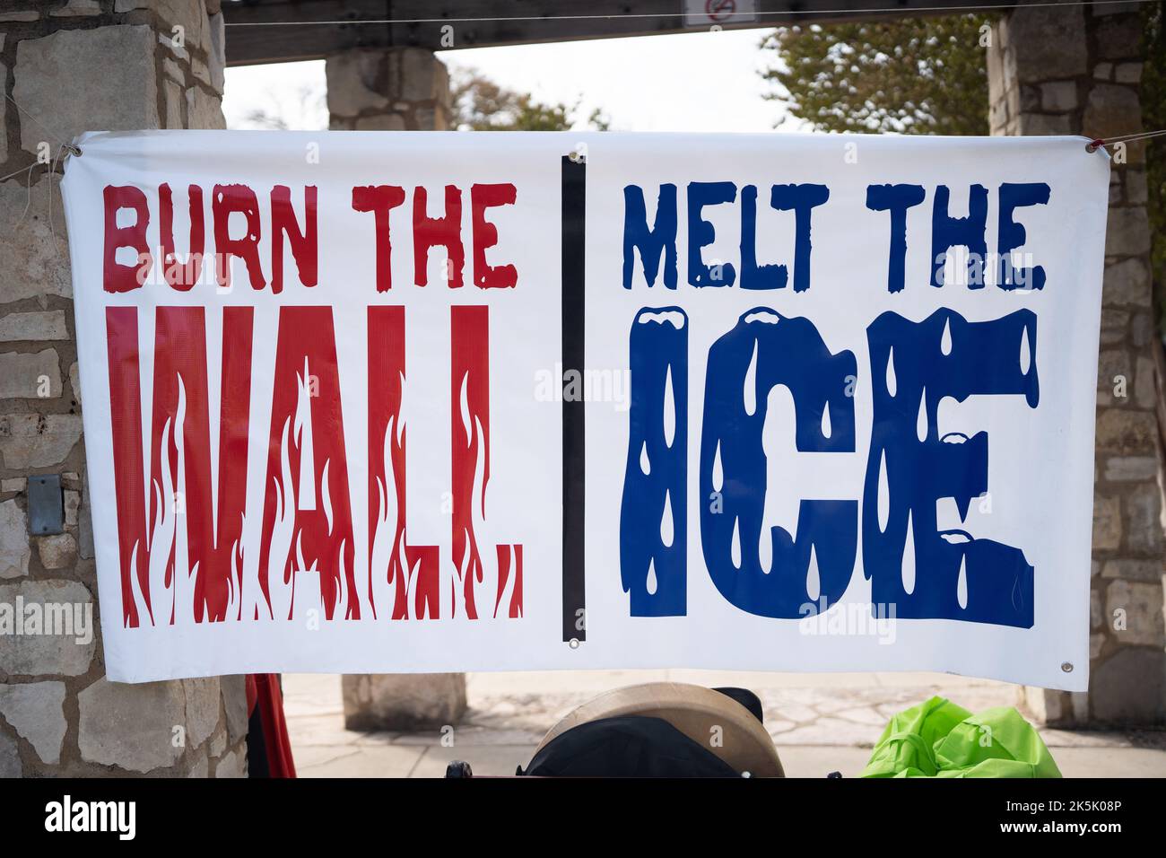 Ein Zeichen gegen die Einwanderungskontrolle, das dazu aufruft, „die Mauer zu verbrennen, das EIS zu schmelzen“, hängt bei einer Kundgebung zum Tag der indigenen würde in San Antonio, Texas. Stockfoto