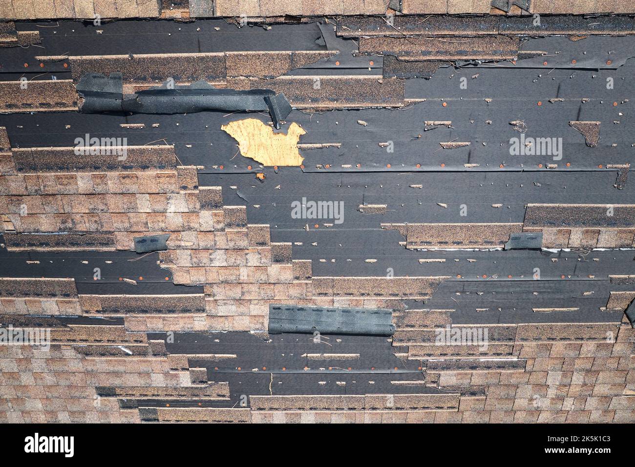 Beschädigtes Hausdach mit fehlenden Schindeln nach Hurrikan Ian in Florida. Folgen einer Naturkatastrophe. Stockfoto