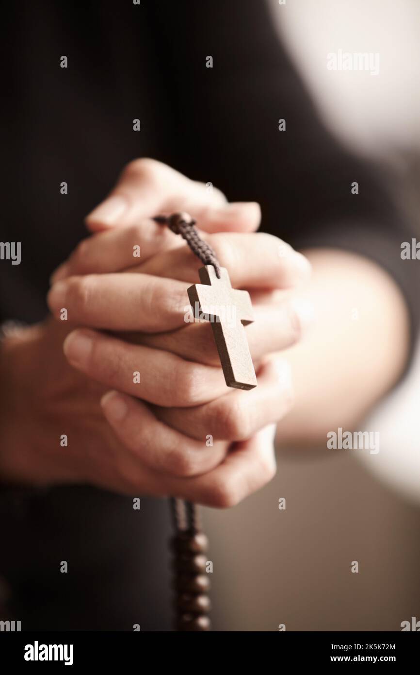 Getreu seiner Religion. Die Hände umklammten und hielten einen Rosenkranz im Gebet. Stockfoto