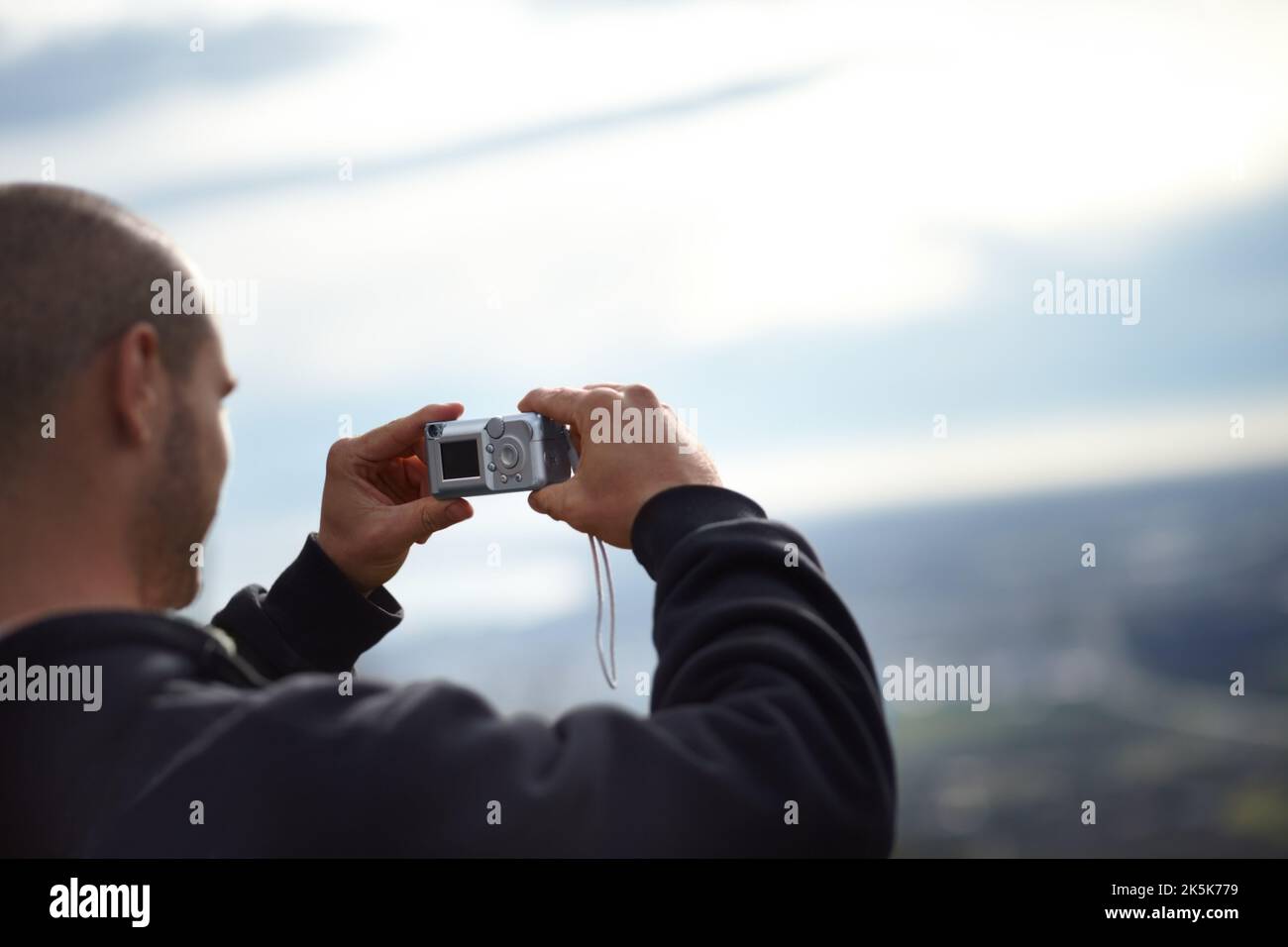 Erinnerungen festhalten. Ein junger Wanderer, der mit seiner Kamera eine Momentaufnahme des Blickes machte. Stockfoto