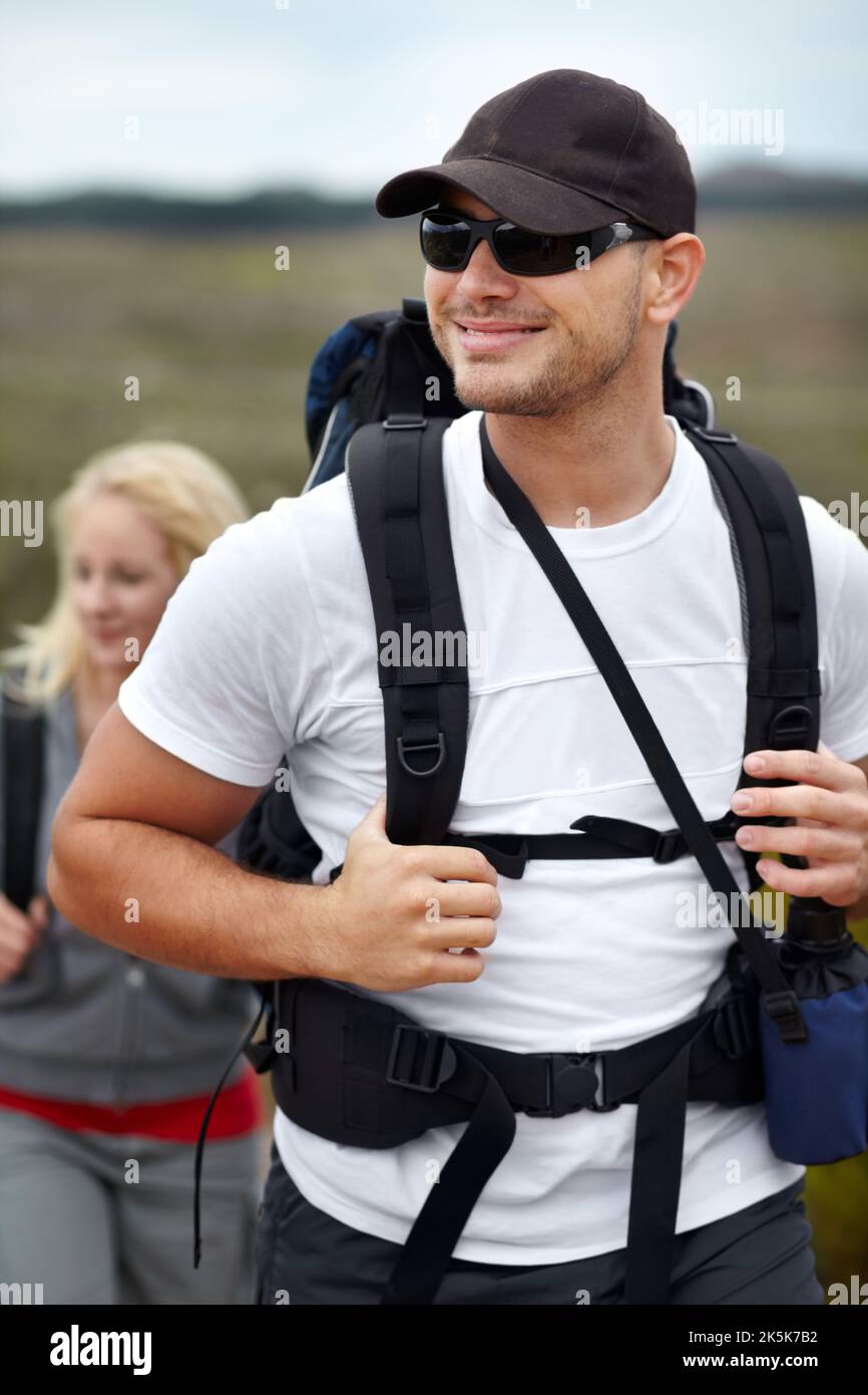 Er liebt die freie Natur. Ein glückliches junges Paar, das mit seinen Rucksäcken wandert. Stockfoto