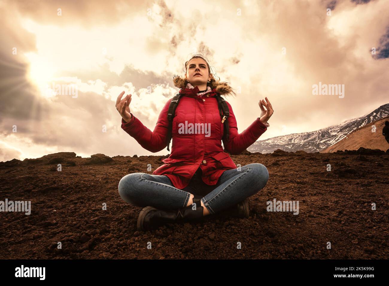 Wanderfrau auf dem Lavastein sitzend Yoga auf dem Gipfel des Berges üben - warm Sunset Filter - Menschen und Fernweh Lifestyle-Konzept Stockfoto