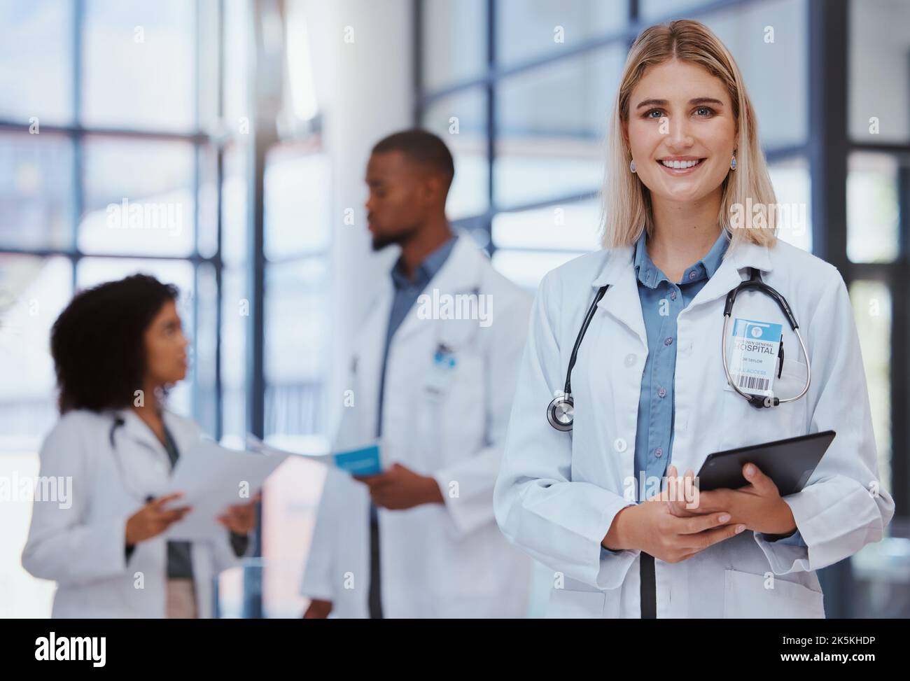 Frau, Team und Porträt eines Arztes mit Tablette im Krankenhaus. Ärztin, lächelnd und Vielfalt in der Gesundheitsversorgung, Medizin und medizinische Versorgung mit Stockfoto