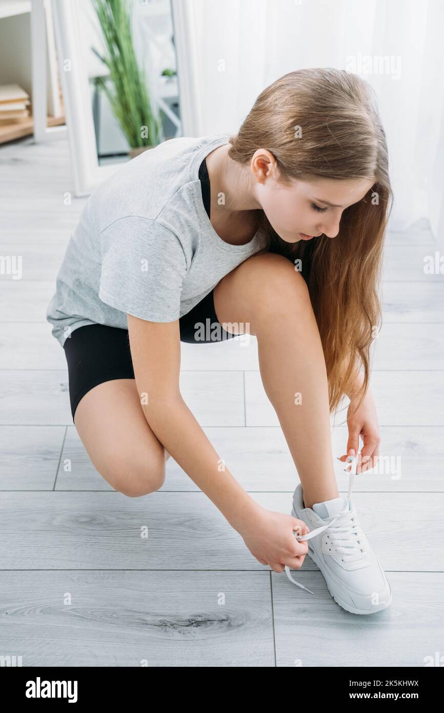 Aktive Kinder Heim Fitnessstudio athletische Mädchen binden Schnürsenkel Stockfoto
