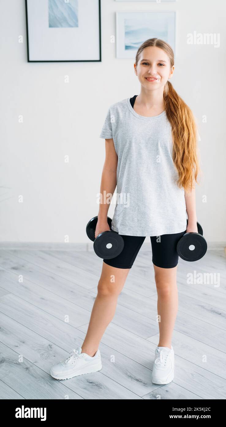 Kids Fitness Home Workout Mädchen mit Hanteln Stockfoto