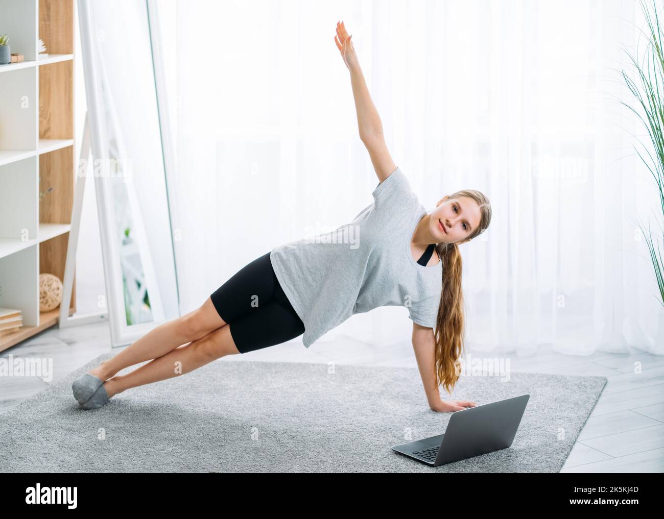 Kid Home Fitness Pilates online Mädchen hält Plank Stockfoto