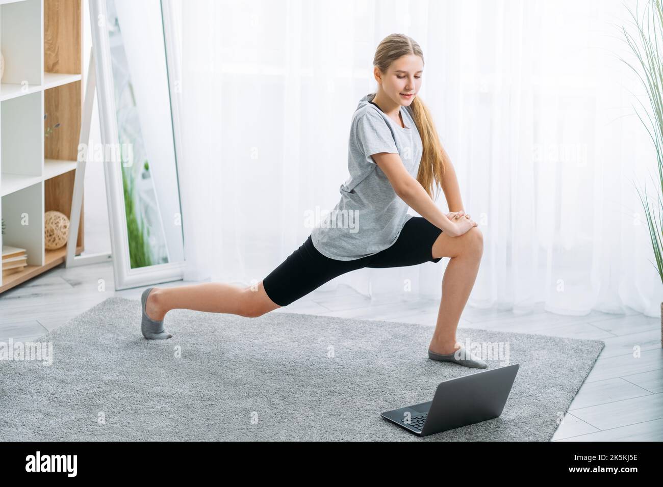 Online-Fitness-Training Kind Heimsport Mädchen Laptop Stockfoto