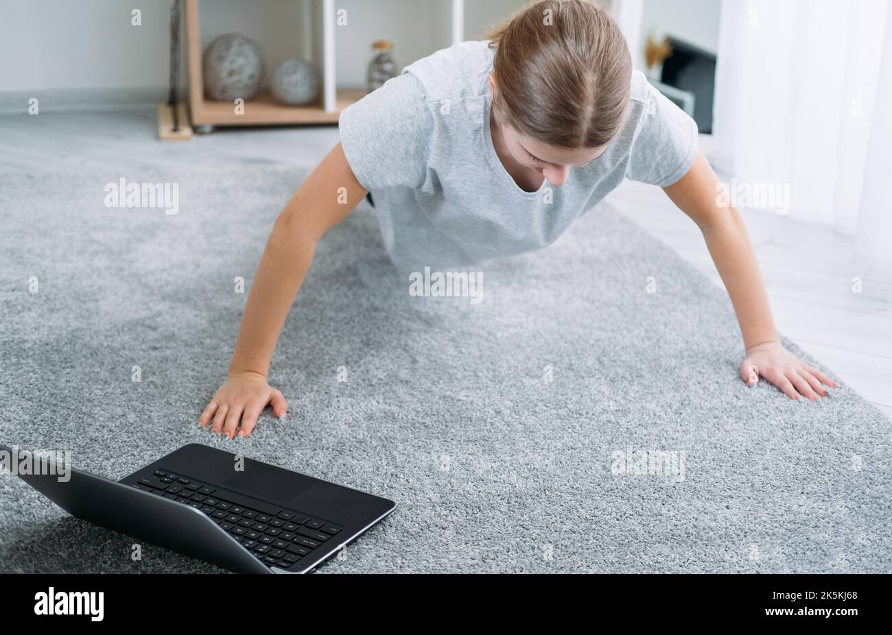 Fitness Online-Heimtraining Mädchen Übung Laptop Stockfoto