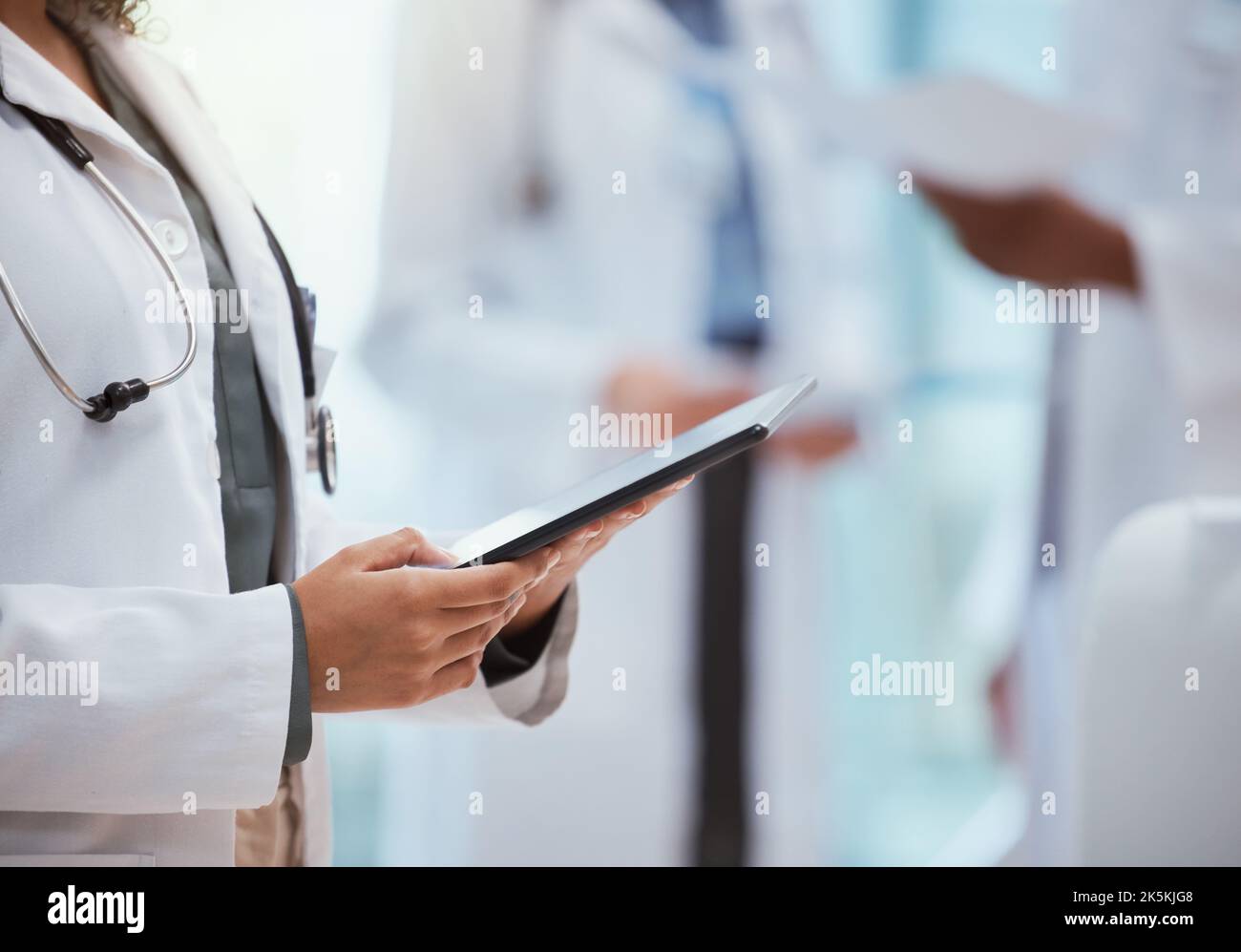 Arzt, Hände und digitale Tablette überprüfen medizinische Daten, Tests und Forschung im Krankenhaus vor einem verschwommenen Hintergrund. Arzt im Gesundheitswesen Stockfoto