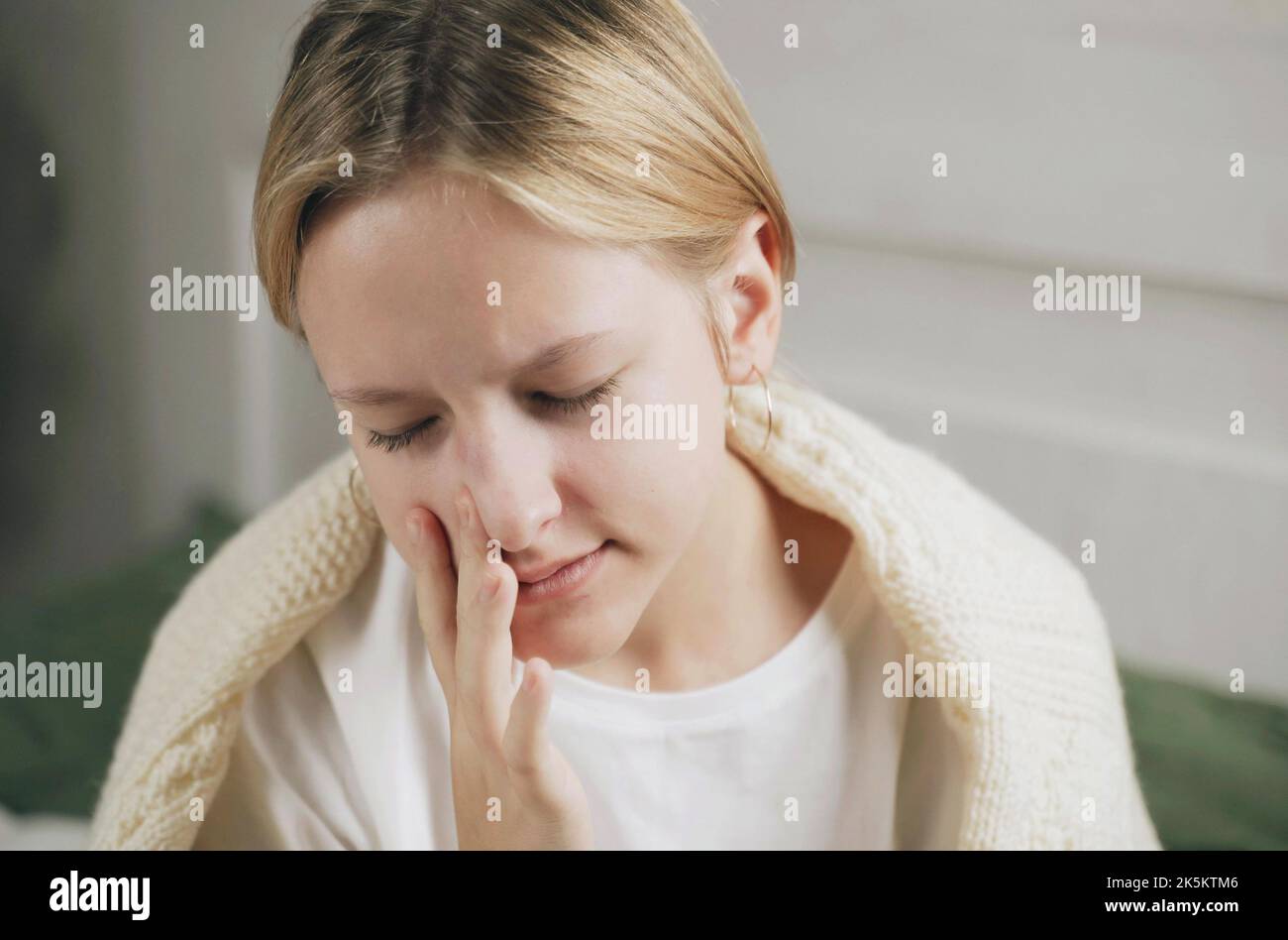 Ein ungesundes Mädchen mit einer verstopften Nase verwendet ein Nasenspray, um eine Erkältung zu behandeln. Medikamente gegen verstopfte Nase und Allergien Stockfoto