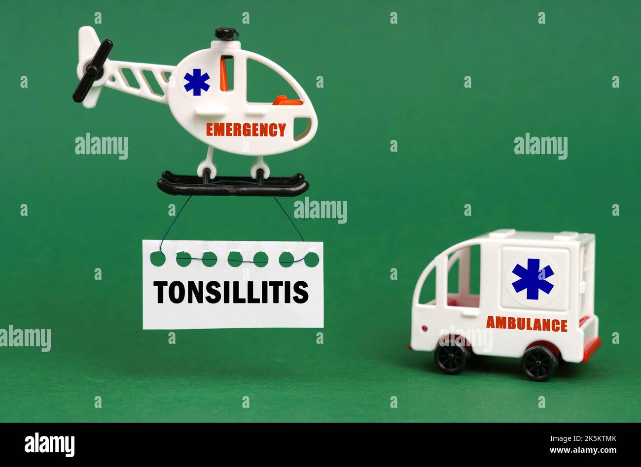 Medizinisches Konzept. Auf einer grünen Fläche, einem Krankenwagen und einem Hubschrauber mit einem Schild - Tonsillitis Stockfoto